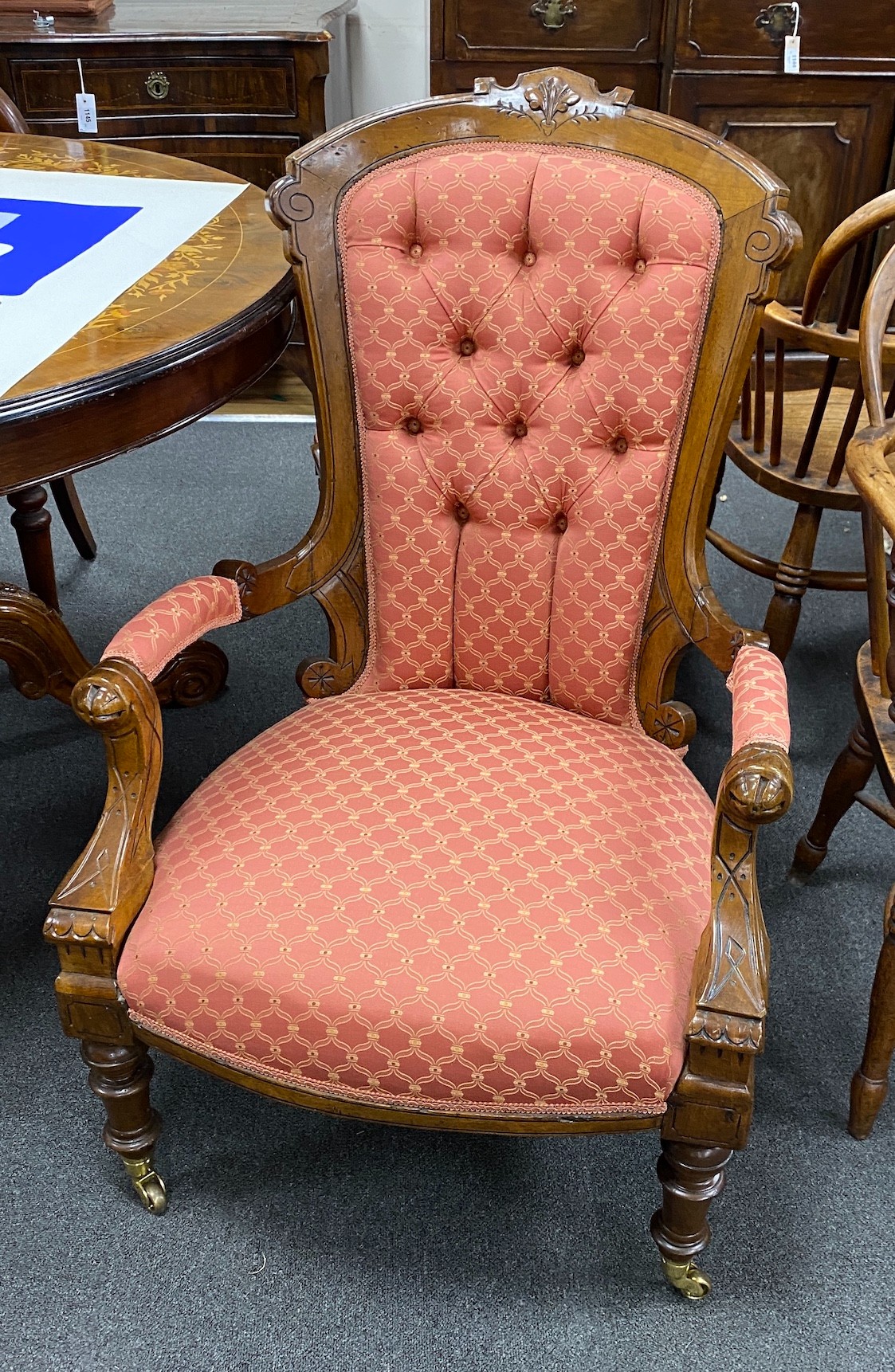 A pair of late Victorian walnut spoon back upholstered chairs, one with arms